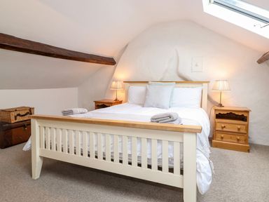 A bedroom with a bed with folded towels bedside tables with lamps and a skylight at Middletown in Keswick