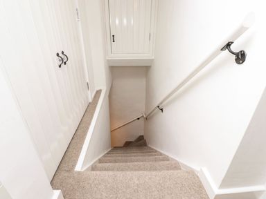 A carpeted staircase with white walls and a handrail at Middletown in Keswick