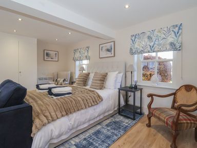 A bedroom with a bed sofa armchair wooden chair and side tables at Providence Court Near Easingwold