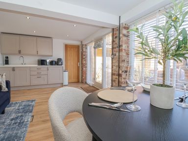 A kitchen and dining area with a round table set for two and grey cabinets at Providence Court Near Easingwold