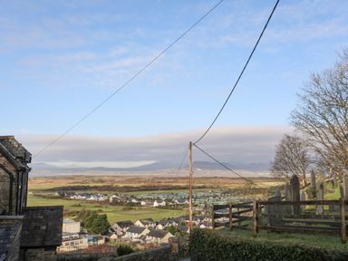 A rural landscape with houses fields and gravestones on a hill at Gwelfor in Harlech