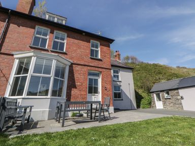 A house with a table and chairs in the outdoor area at Brynmorfa in Llandysul