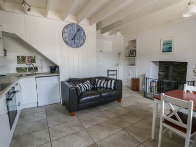 A living room with a couch and dining table at Brynmorfa in Llandysul