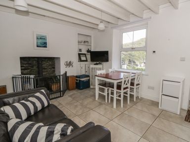 A living room with a dining table and chairs at Brynmorfa in Llandysul