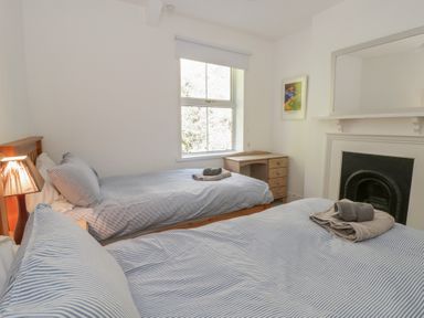 A bedroom with two beds and a dresser at Brynmorfa in Llandysul