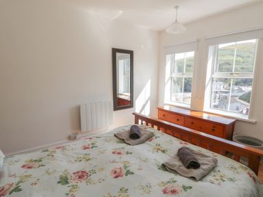 A bedroom with a bed and dresser at Brynmorfa in Llandysul