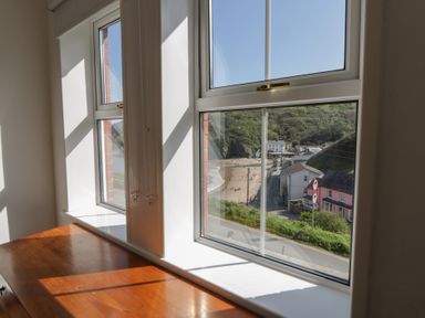 A view of houses and a beach from a window at Brynmorfa in Llandysul