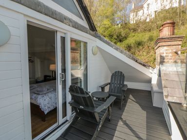 A deck with chairs and a table at Brynmorfa in Llandysul