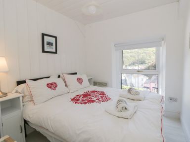 A bedroom with a bed, pillows, and a window at Brynmorfa in Llandysul