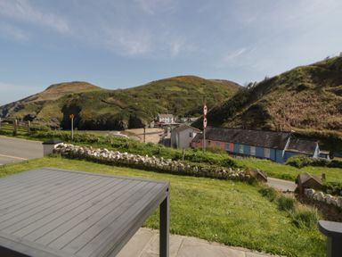 A view of mountains and houses from a patio at Brynmorfa in Llandysul