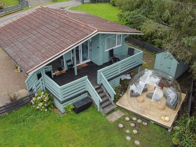 A house with a deck and outdoor furniture at Scarba Balvicar, Isle Of Seil