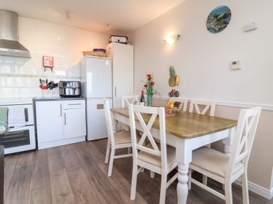 A kitchen with a dining table and chairs at Castle View Lodge in Ilfracombe
