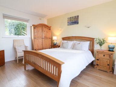 A bedroom with a bed and wooden furniture at Castle View Lodge in Ilfracombe
