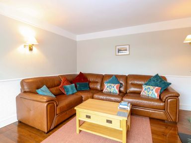 A living room with a sofa and coffee table at Highland House in Sheringham