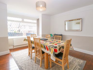 A dining room with a table and chairs at Highland House in Sheringham