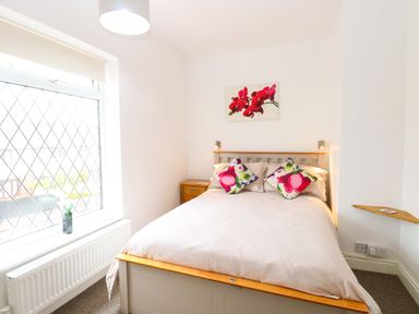 A bedroom with a bed and window at Highland House in Sheringham