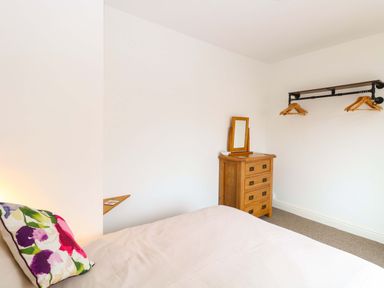 A bedroom with a bed and dresser at Highland House in Sheringham