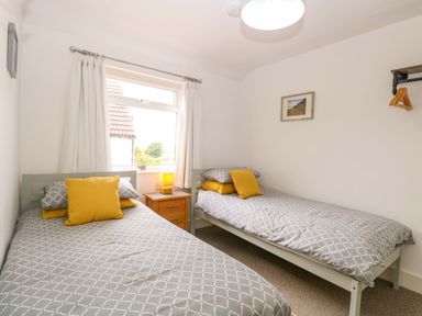A bedroom with two beds and a nightstand at Highland House in Sheringham