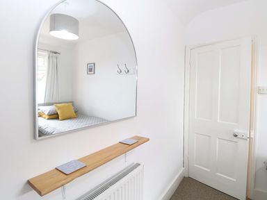 A bedroom with a mirror and shelf at Highland House in Sheringham