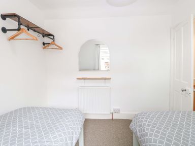 A bedroom with beds and a mirror at Highland House in Sheringham