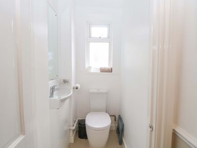 A bathroom featuring a toilet and sink at Highland House in Sheringham