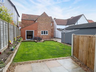 A garden with lawn and seating area at Highland House in Sheringham