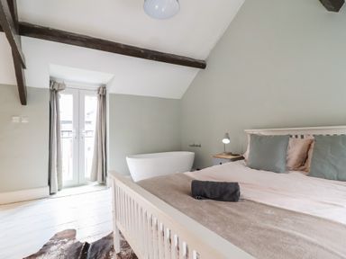A bedroom with a bed and bathtub at Riverwash Cottage in Dwygyfylchi