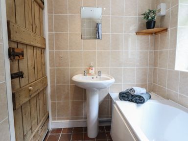 A bathroom with a sink and bath tub at Riverwash Cottage in Dwygyfylchi
