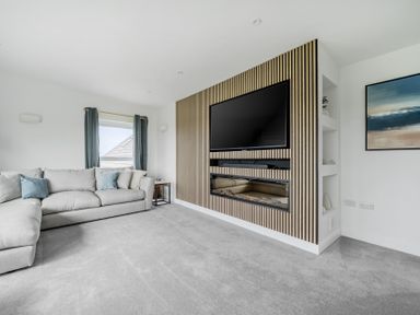 A living room with a sofa and television at Seaddler in Trearddur Bay