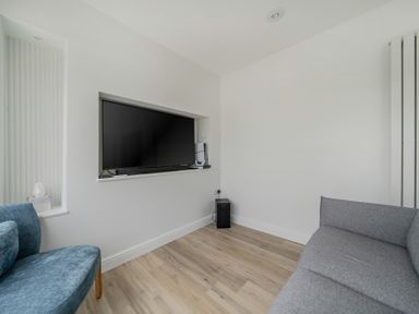 A living room with a television mounted on the wall at Seaddler in Trearddur Bay