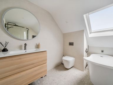 A bathroom with a bathtub and vanity at Seaddler in Trearddur Bay