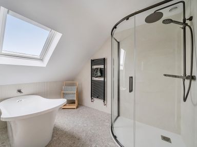 A bathroom with a bathtub and shower at Seaddler in Trearddur Bay