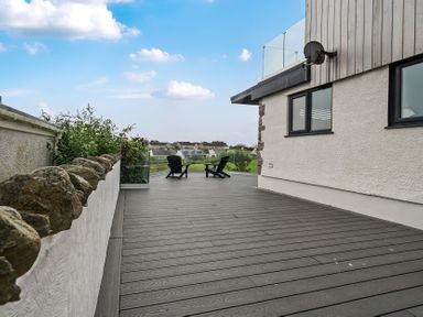 An outdoor deck with chairs and plants at Seaddler in Trearddur Bay