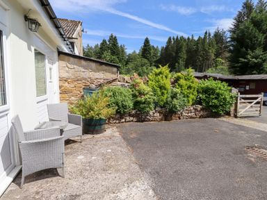 An outdoor area with a table and chairs at Stable Cottage Cottonshopeburnfoot near Otterburn