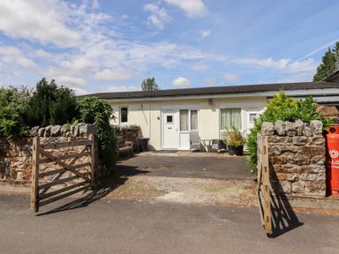 An exterior view of a cottage with a gate and plants at Stable Cottage Cottonshopeburnfoot near Otterburn