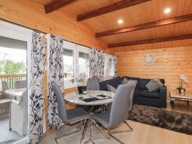 A dining area with a round table and four chairs next to a sitting area with a sofa and a coffee table at Owenbeg in Dungiven Londonderry