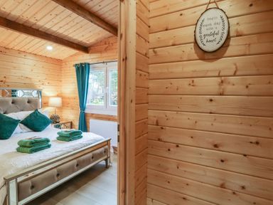 A bedroom with a bed towel stacks and a window with curtains at Owenbeg in Dungiven Londonderry