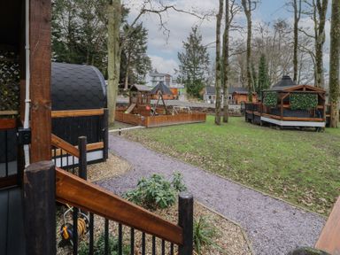 An outdoor area with wooden structures trees a playground and pathways at Hazel in Dungiven Londonderry