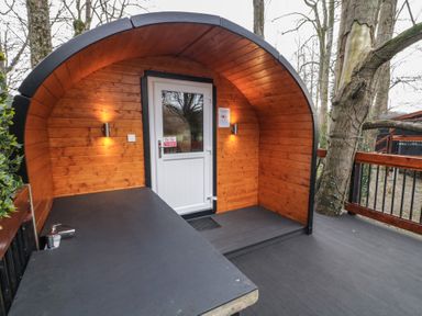 An outdoor wooden pod with a curved roof an entry door and a black countertop with a faucet at Juniper in Dungiven Londonderry