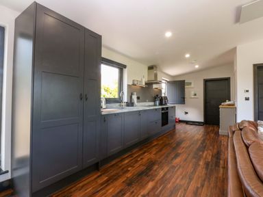 A kitchen with cabinets, sink, and appliances at Y Cwt in Moelfre