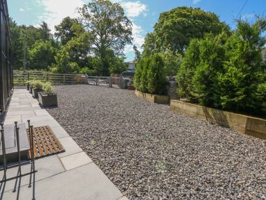 A garden with gravel and planters at Y Cwt in Moelfre