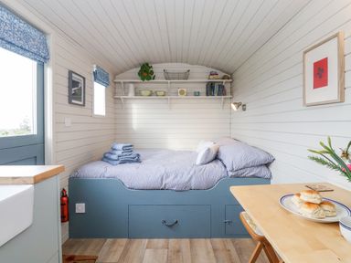 A small bedroom with a bed and shelves above at Teg in Prospidnick near Porthleven