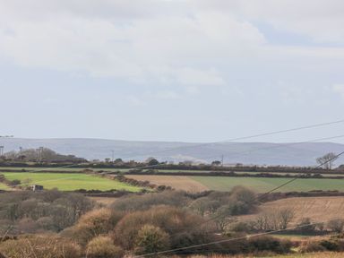 An outdoor landscape with fields trees electricity poles and hills at Teg in Prospidnick near Porthleven