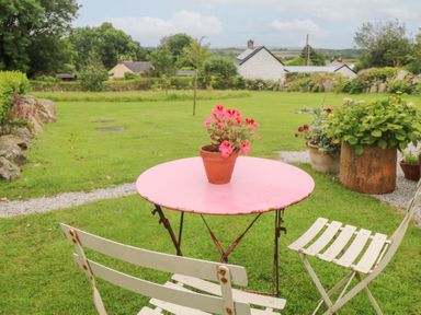 An outdoor area with a table and chairs at Teg in Prospidnick near Porthleven