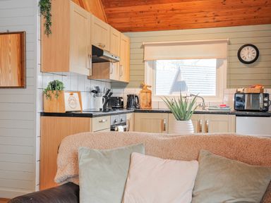 A kitchen with cabinets and appliances at Cornish Woodland Retreat Near St Tudy