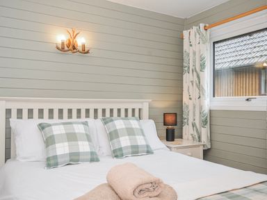 A bedroom with a bed and window at Cornish Woodland Retreat Near St Tudy