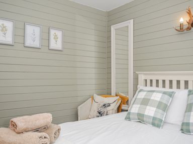 A bedroom with a bed and towels at Cornish Woodland Retreat near St Tudy