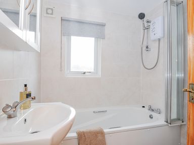A bathroom with a bathtub and a shower at Cornish Woodland Retreat near St Tudy