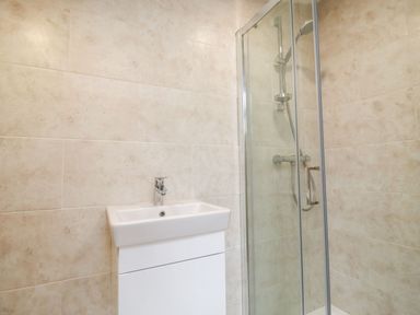 A bathroom with a white sink and a glass-enclosed shower at Bears Court Barn 3 in Little Rissington near Bourton-On-The-Water