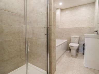 A bathroom with a shower enclosure bathtub toilet and sink at Bears Court Barn 4 Little Rissington near Bourton-On-The-Water